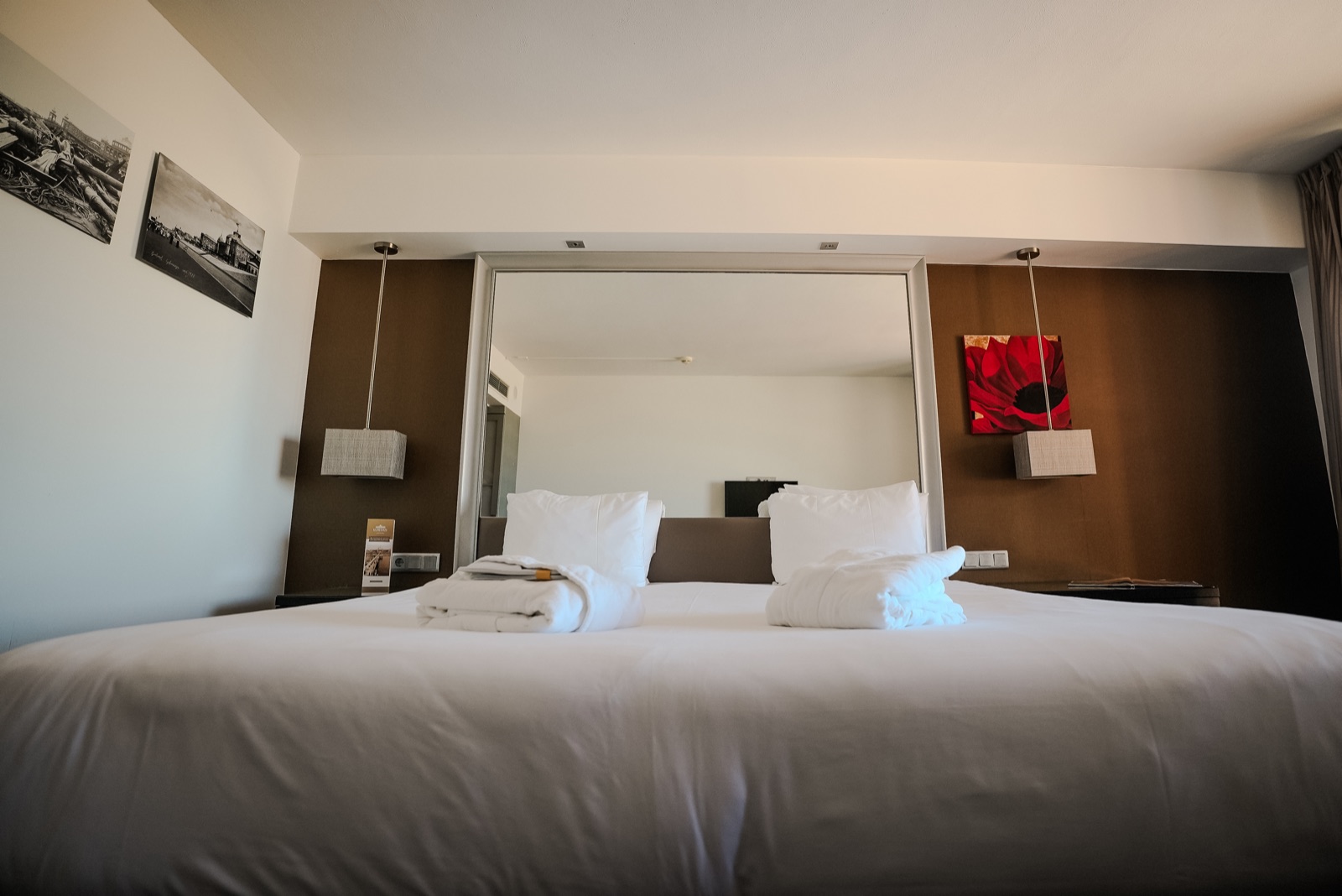 Freshly made Kurhaus hotel bed with folded bathrobes